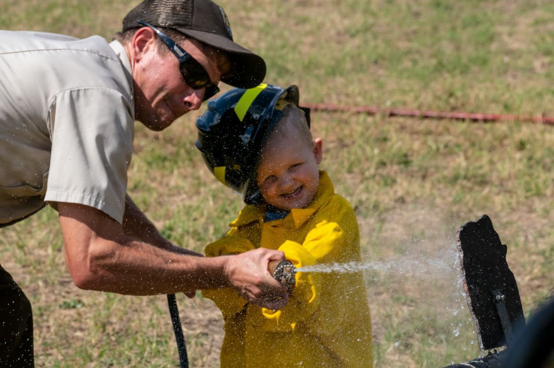 Child and man with a hose